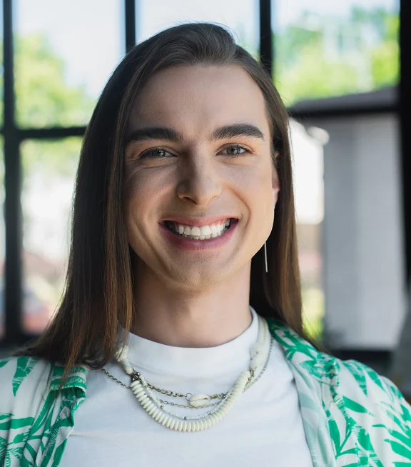 Positive nonbinary person looking at camera in office